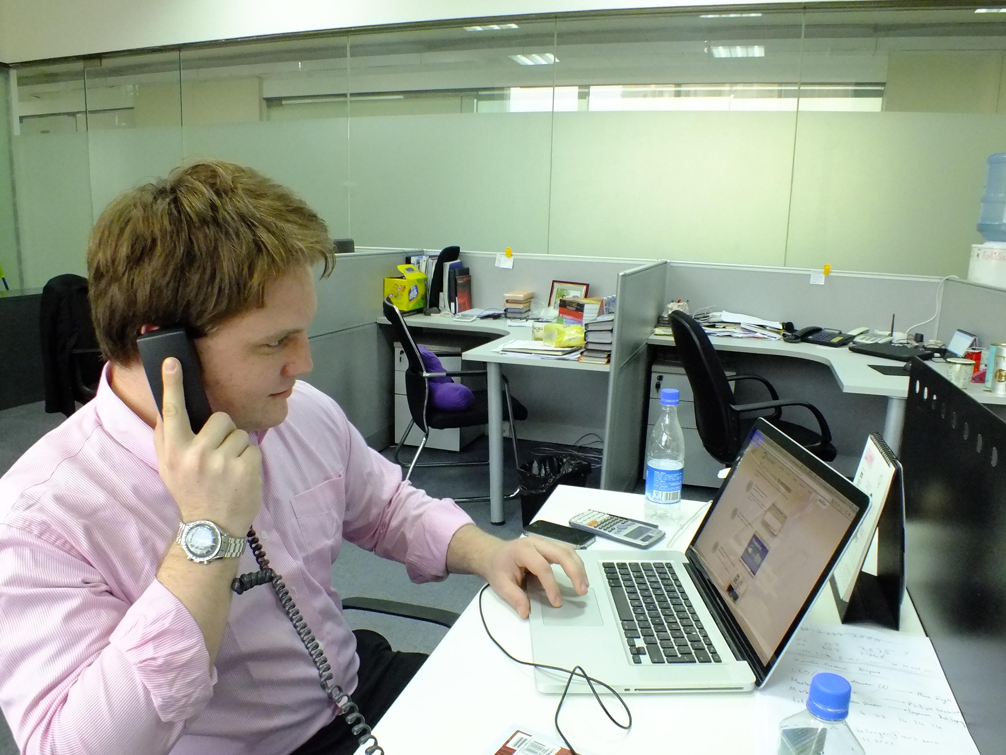 A legal intern consults with a client on the phone at his Law placement in China. A student doing a Law internship in China discusses a case with a client over the phone in Shanghai.